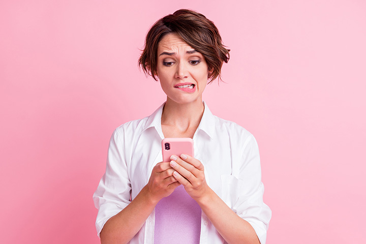 Frau sieht zweifelnd auf ihr Handy