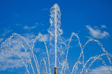 Wasserfontäne vor blauem Himmel